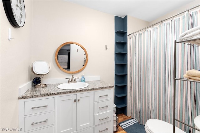 bathroom with toilet, walk in shower, hardwood / wood-style flooring, and vanity