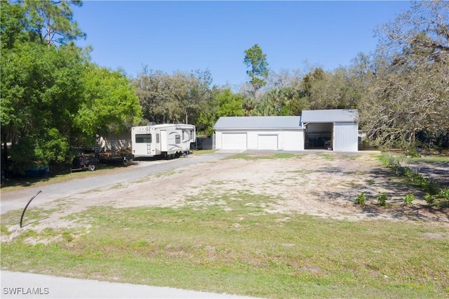 exterior space with driveway and a detached garage