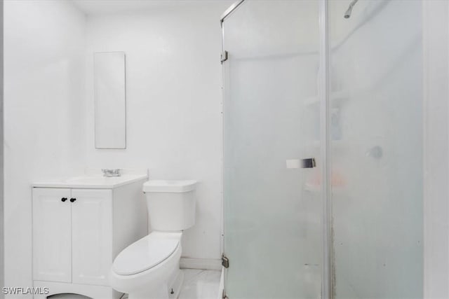 bathroom with a shower with shower door, toilet, and vanity