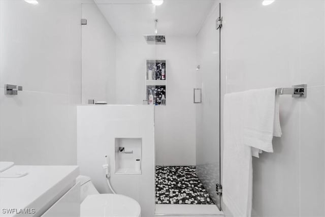 bathroom with toilet, vanity, and walk in shower