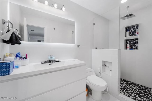 bathroom featuring toilet, vanity, and walk in shower