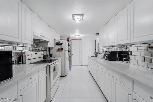 kitchen featuring white cabinets, light tile patterned floors, sink, and white appliances