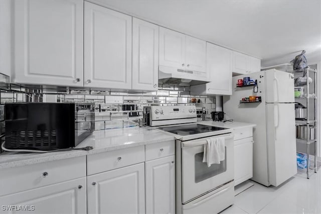 kitchen with white appliances, white cabinetry, tasteful backsplash, light tile patterned flooring, and light stone counters