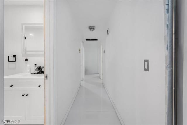 corridor with light tile patterned floors and sink