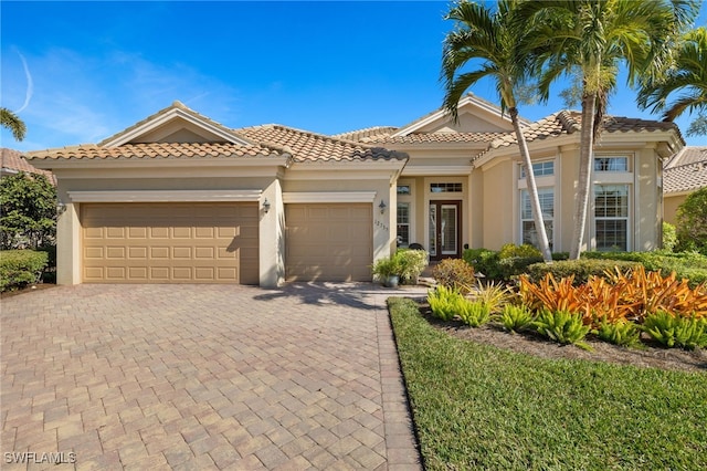 12735 Kingsmill Way, Fort Myers, FL 33913 - view of front facade featuring stucco siding, an attached garage, french doors, driveway, and a tile roof