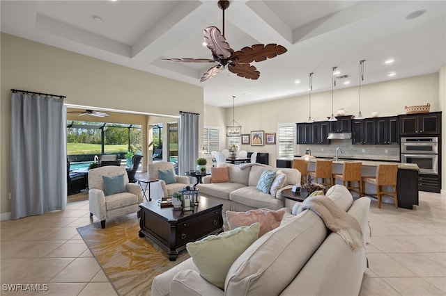 tiled living room featuring beam ceiling, a towering ceiling, ceiling fan, coffered ceiling, and sink