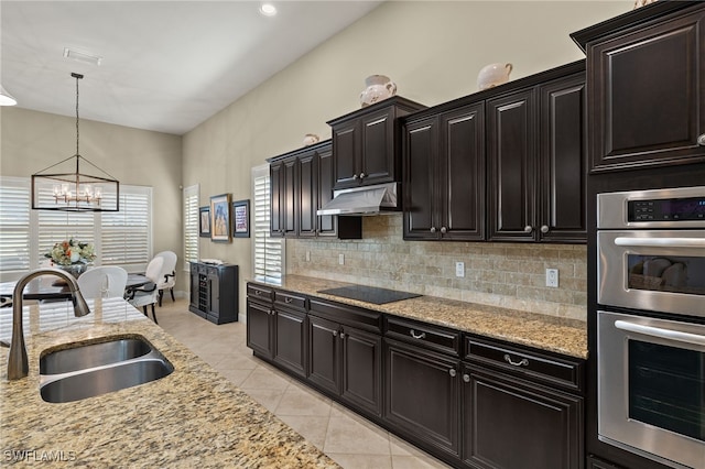 kitchen featuring hanging light fixtures, stainless steel double oven, sink, light tile patterned floors, and decorative backsplash