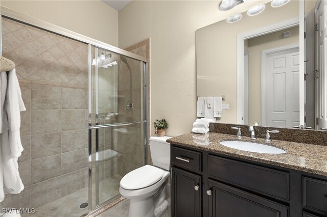 bathroom featuring vanity, toilet, and walk in shower