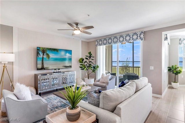 living room with ceiling fan, ornamental molding, and plenty of natural light