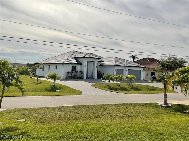 view of front of property with a garage and a front lawn