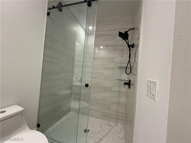 bathroom featuring an enclosed shower and toilet