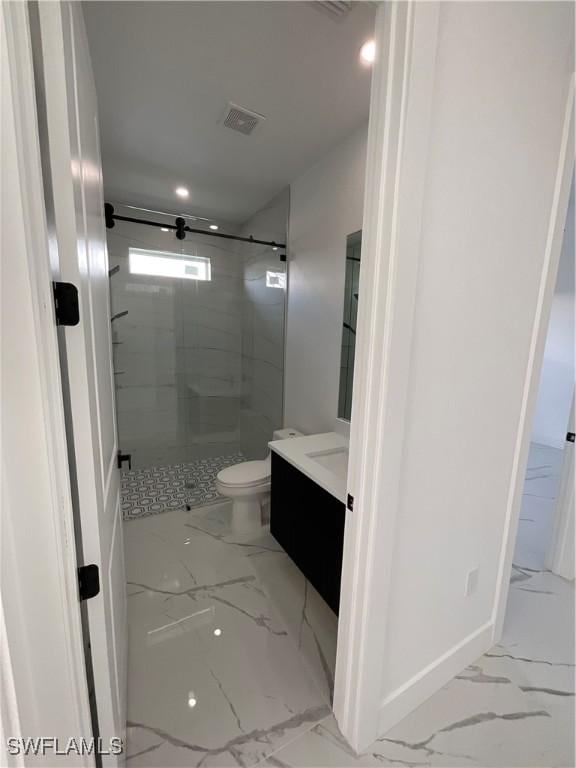 bathroom featuring vanity, toilet, and a shower with shower door