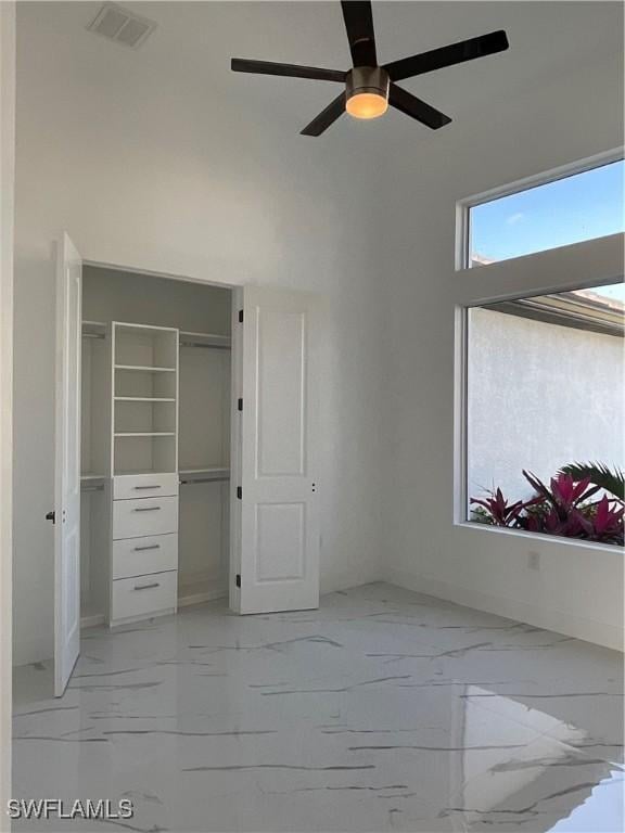 unfurnished bedroom featuring ceiling fan and a closet