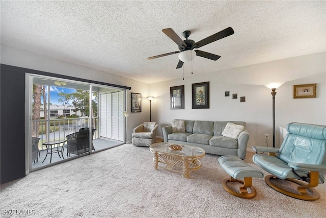 living room featuring carpet floors, ceiling fan, and a textured ceiling