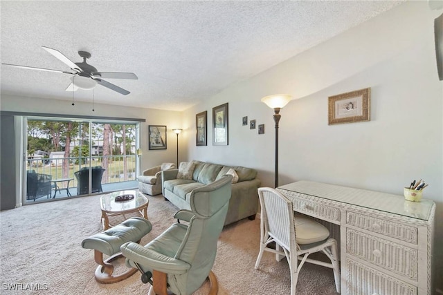 living room with light carpet, ceiling fan, a textured ceiling, and built in desk