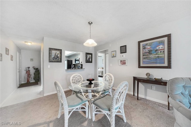 dining area with light carpet and a textured ceiling