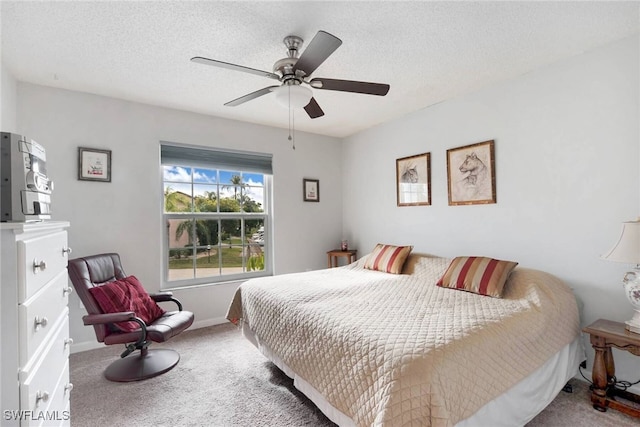 carpeted bedroom featuring ceiling fan and a textured ceiling