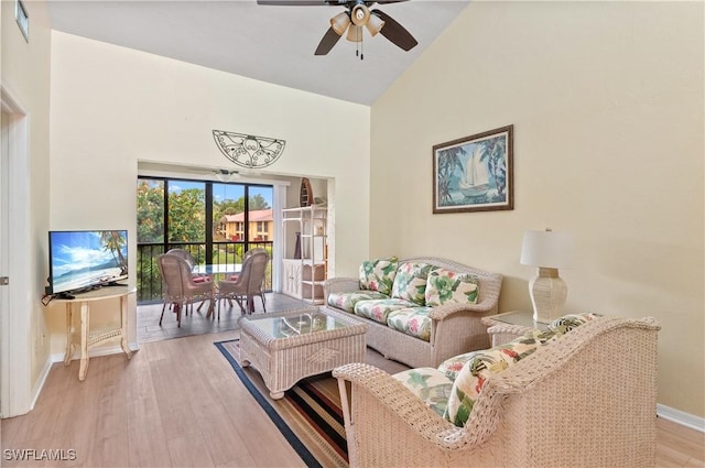 living room with light hardwood / wood-style floors, high vaulted ceiling, and ceiling fan