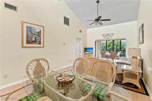 dining area with high vaulted ceiling and ceiling fan