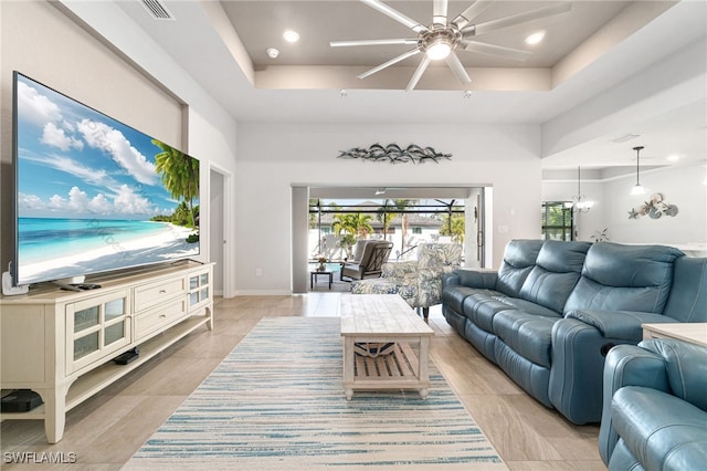 living room featuring ceiling fan and a tray ceiling