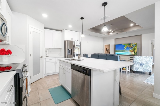 kitchen with sink, white cabinetry, stainless steel appliances, and an island with sink