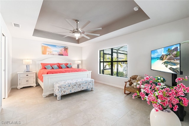 bedroom featuring ceiling fan and a raised ceiling