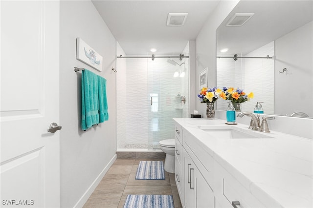 bathroom featuring a shower with shower door, tile patterned floors, toilet, and vanity