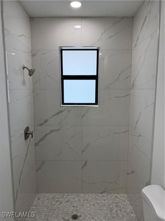 bathroom with toilet and a tile shower