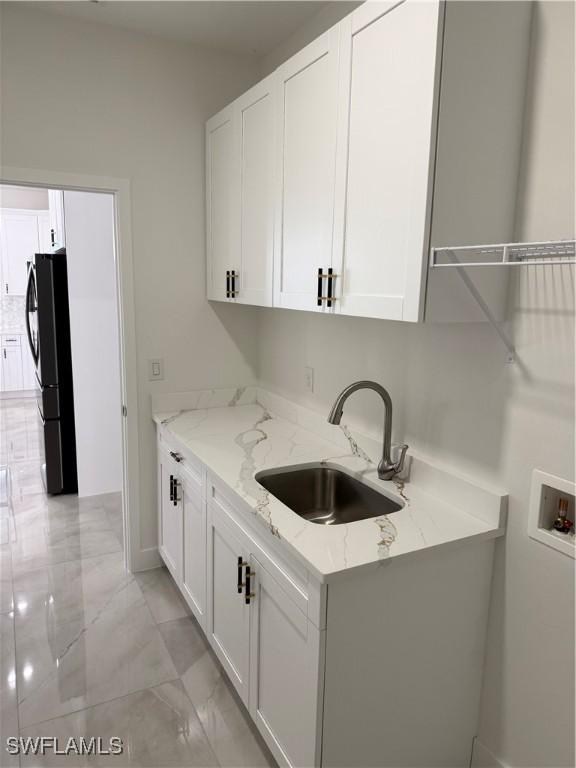 clothes washing area featuring washer hookup, cabinets, and sink