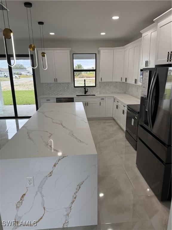 kitchen featuring sink, white cabinetry, black appliances, and decorative light fixtures