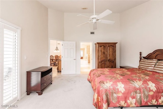 bedroom with light carpet, a high ceiling, and visible vents