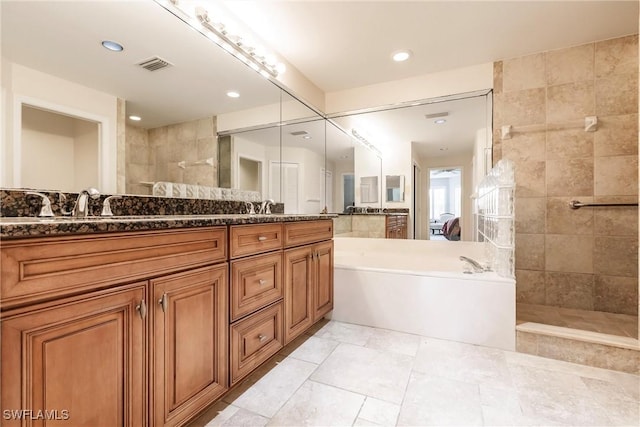 full bathroom with double vanity, visible vents, a walk in shower, and a bath