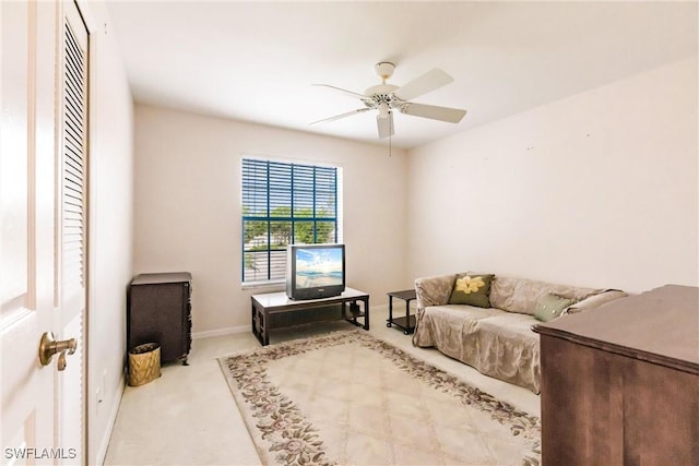 living room with carpet, baseboards, and ceiling fan