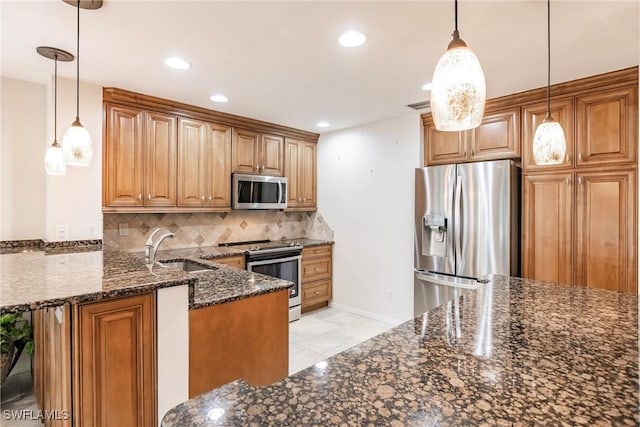 kitchen featuring stainless steel appliances, sink, decorative backsplash, and decorative light fixtures