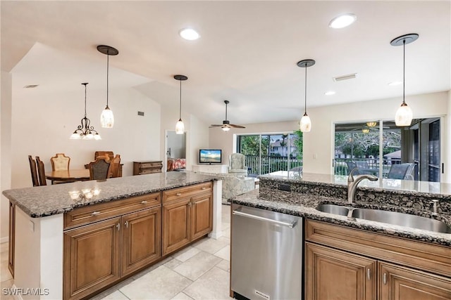 kitchen featuring lofted ceiling, sink, dishwasher, dark stone countertops, and decorative light fixtures