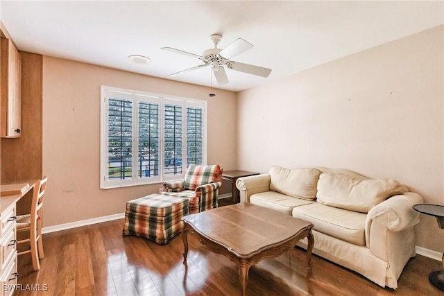 living area with a ceiling fan, baseboards, and wood finished floors