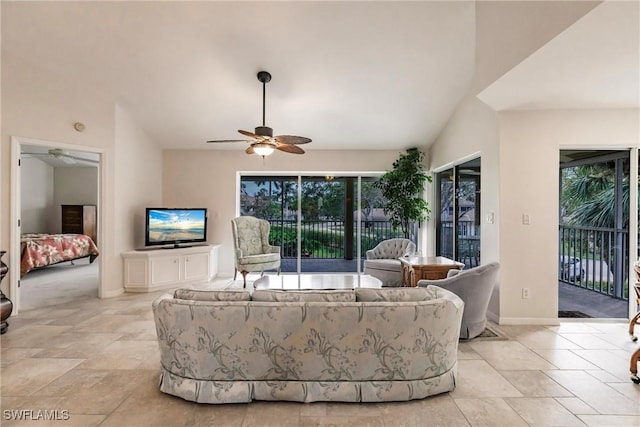 living room featuring vaulted ceiling, baseboards, a ceiling fan, and a healthy amount of sunlight