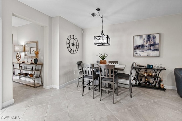 dining room featuring tile patterned floors and an inviting chandelier