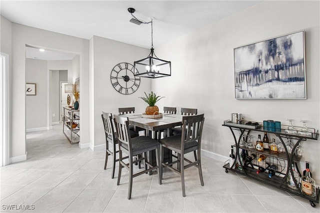 dining area with light tile patterned floors and a notable chandelier