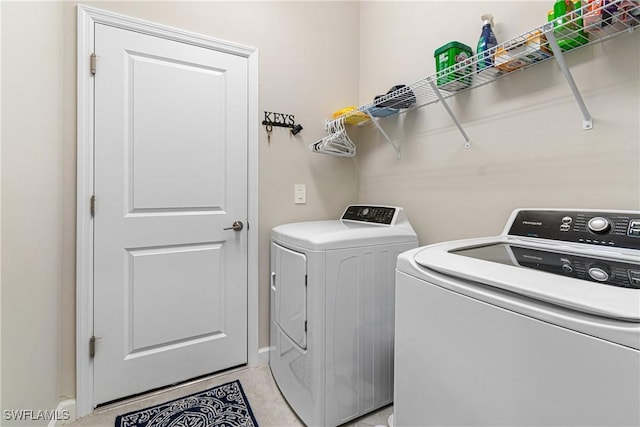 washroom with light tile patterned floors and separate washer and dryer