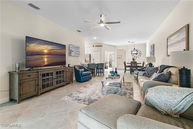 living room featuring light tile patterned flooring and ceiling fan with notable chandelier