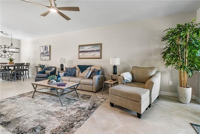 tiled living room with ceiling fan with notable chandelier