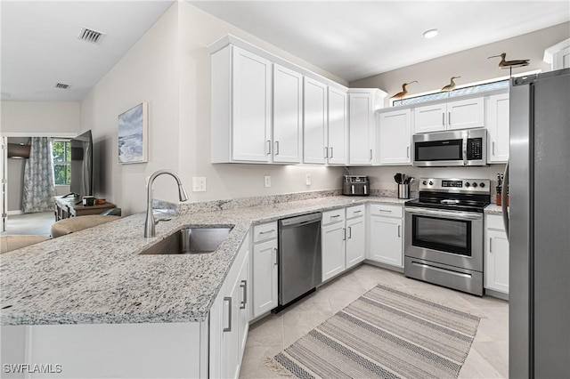 kitchen with kitchen peninsula, sink, stainless steel appliances, and white cabinetry