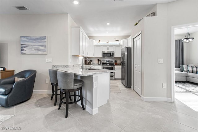 kitchen featuring sink, white cabinetry, kitchen peninsula, and stainless steel appliances