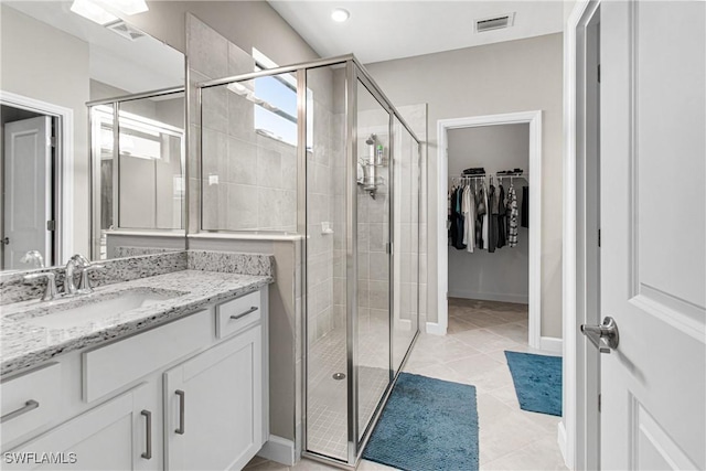 bathroom with vanity, tile patterned flooring, and a shower with door