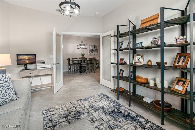 interior space with an inviting chandelier, light tile patterned floors, and french doors