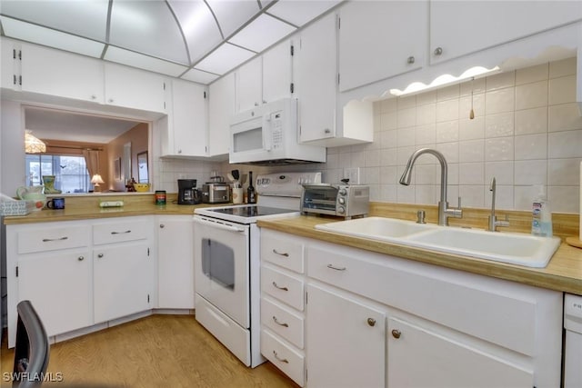 kitchen with tasteful backsplash, white appliances, light wood-type flooring, white cabinets, and sink