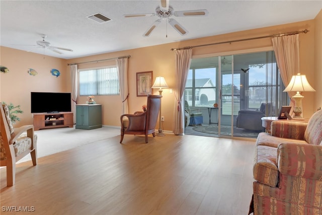 living room featuring ceiling fan and light hardwood / wood-style floors