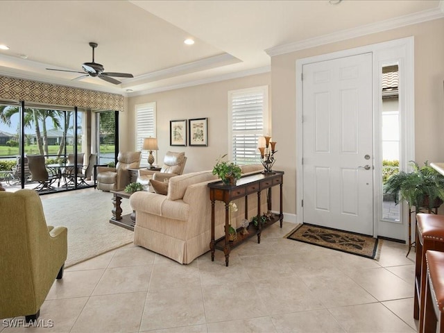 living room featuring ceiling fan, light tile patterned floors, crown molding, and a tray ceiling