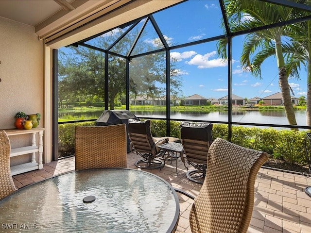 sunroom featuring a water view